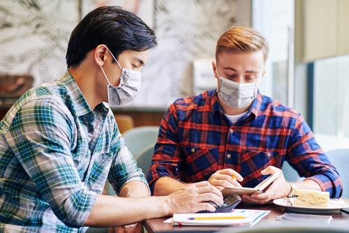 coworkers talking in the office with face masks