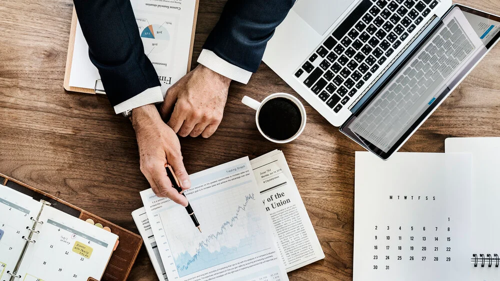 Top view of business data analyst looking through pages of data