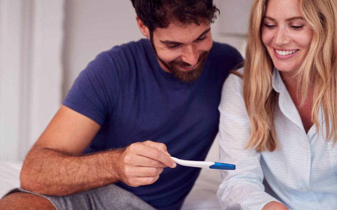 Excited couple looking at pregnancy test